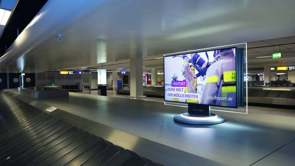 Fraport Kampagnen-Motiv auf einem Bildschirm am Kofferband