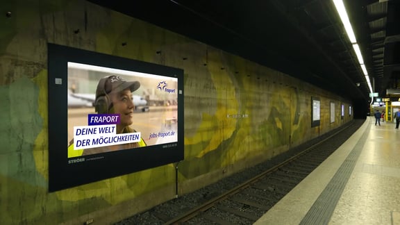Fraport Kampagnen-Motiv auf Bildschirm im U-Bahnhof