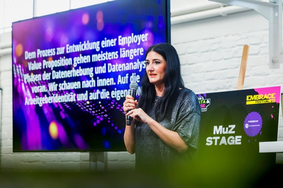 Ricarda Rauch hält auf der Bühne einen Vortrag