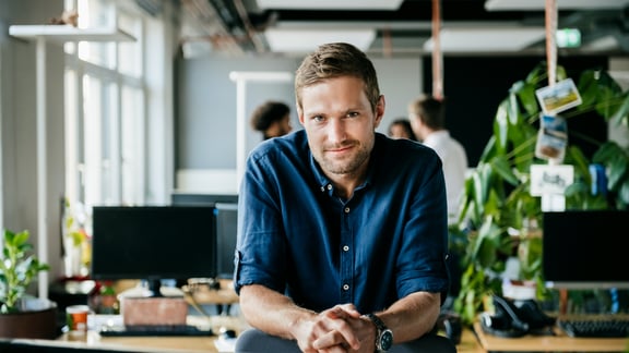 Zufriedener Personalrecruiter in modernem Großraumbüro
